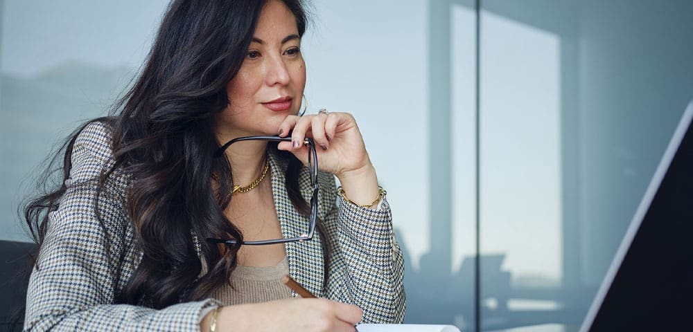 Woman working at desk with glasses