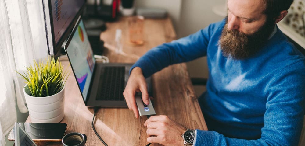 Bearded man using card reader at desk