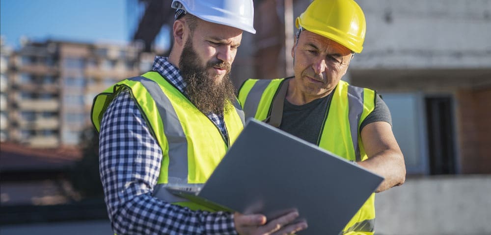 Workers in hard hats examining a document