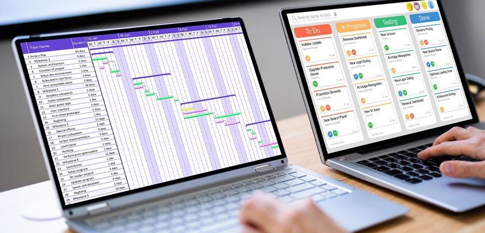 Hands typing on laptops with schedules
